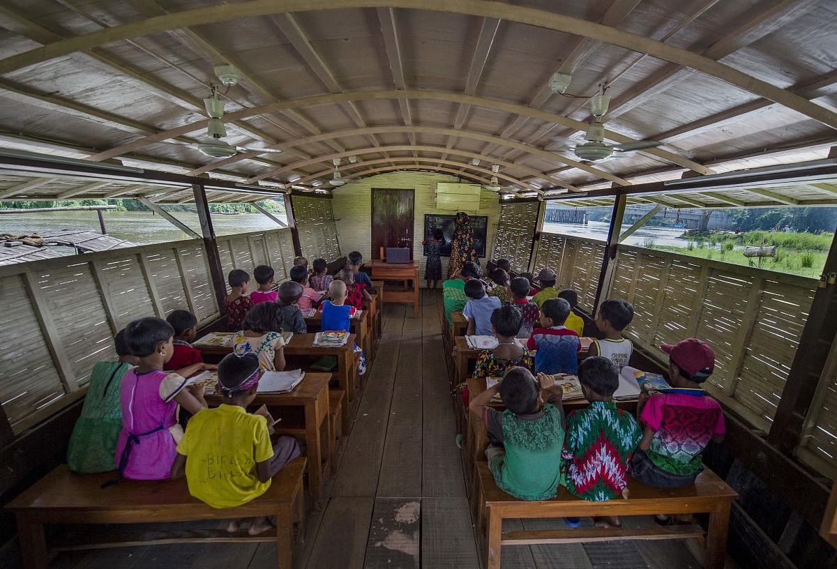 In this photograph taken on September 4, 2018, Bangladeshi students attend a "floating school", operated by the Shidhulai Swanirvar Sangstha (SSS) charity, in Chalan Beel in Rajshahi district. AFP