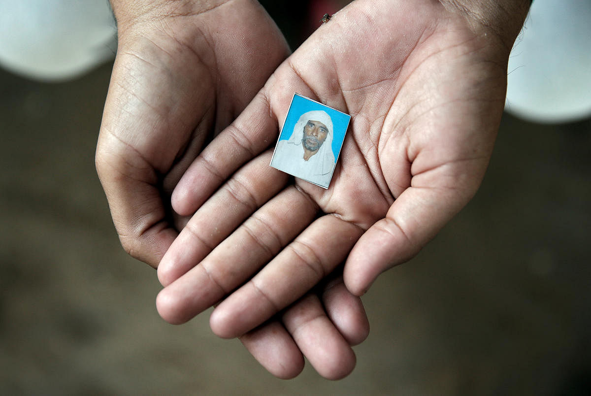 Irshad Khan, 24, holds a picture of his late father Pehlu, 55, in Jaisinghpur. (Reuters File Photo)