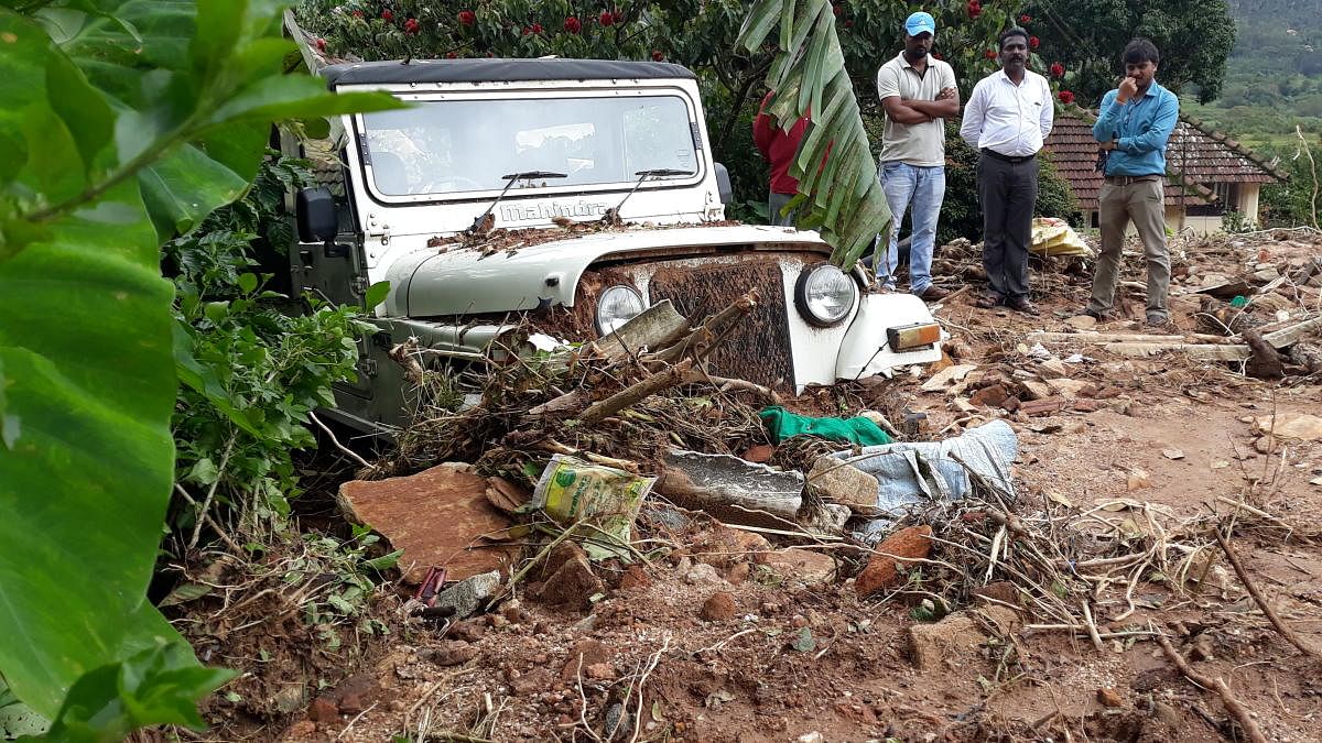 A jeep belonging to Natesh is half buried after a landslide at Hallikere in Kottigehara.