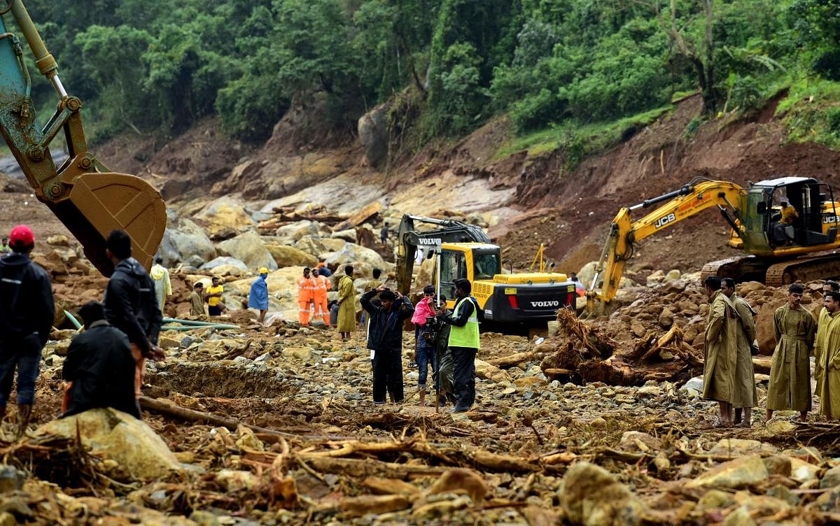 Volunteers, local residents, fire force officials and members of National Disaster Response Force (NDRF) search for survivors following landslides at Puthumala village in Kerala's Wayanad district on August 14, 2019. (Photo by STR / AFP)