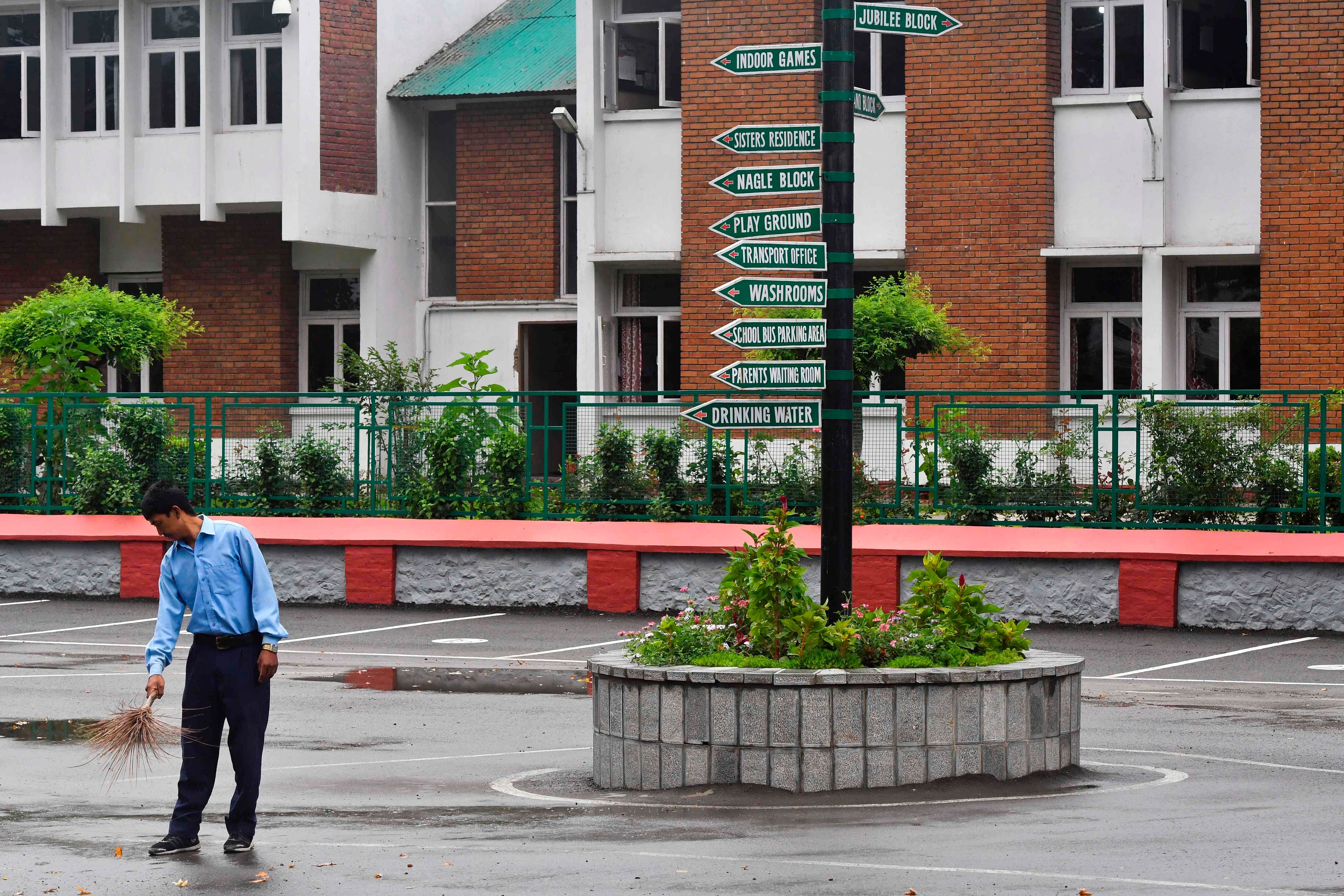 A worker cleans the campus of an empty school in Srinagar. (AFP Photo)