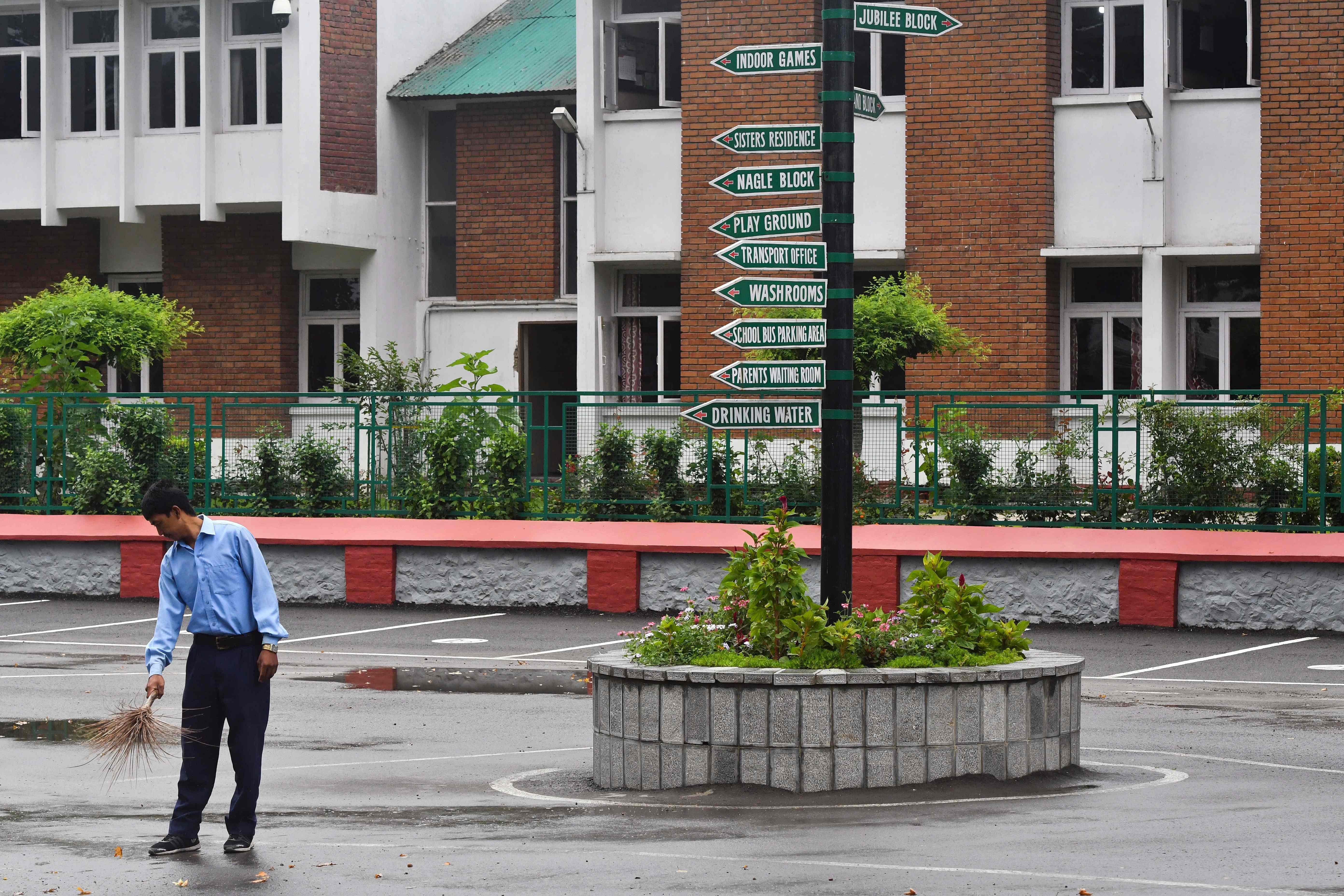 A worker cleans the campus of an empty school in Srinagar. (AFP Photo)