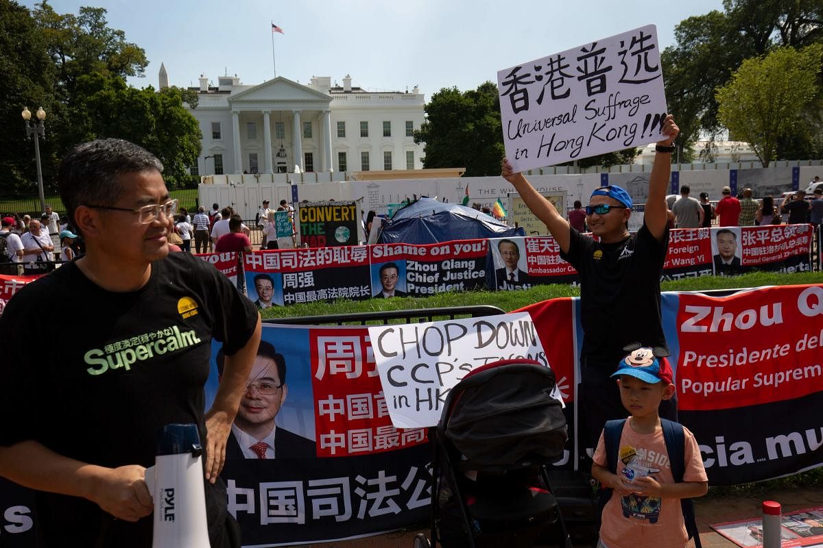 People in support of the ongoing demonstrations in Hong Kong hold placards as they protest at Lafayette Square outside the White House in Washington, DC. AFP