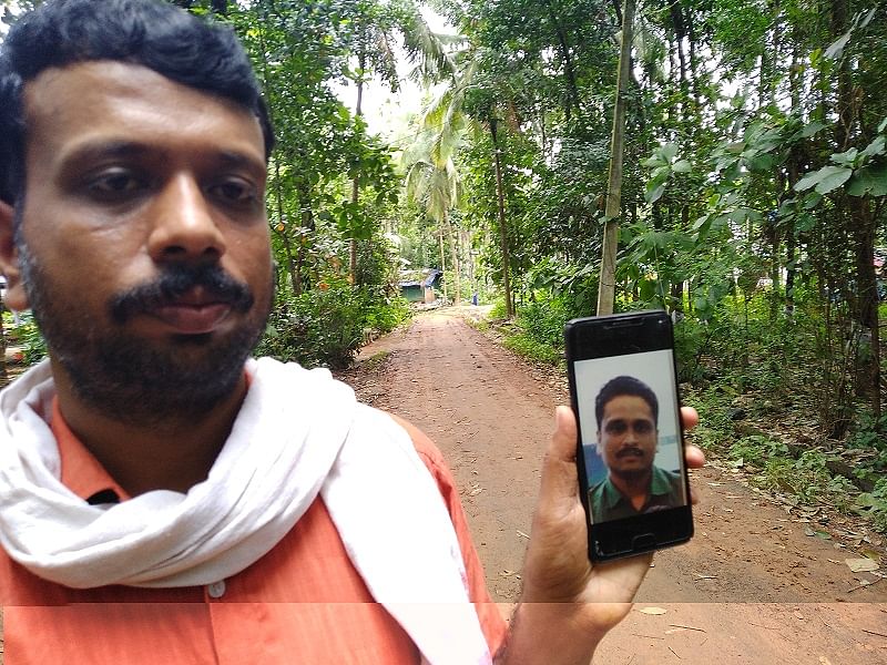 Aneesh's cousin, Dileep shows his photo on the phone (DH Photo)