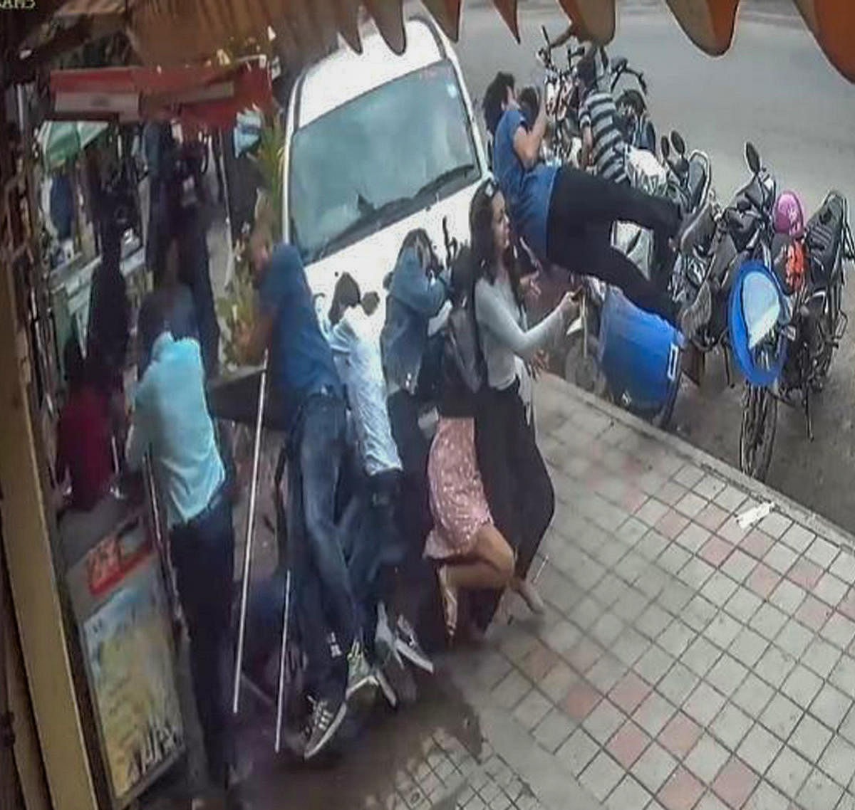 A video grab shows the car climbing the footpath and flinging people in HSR Layout on Sunday. 
