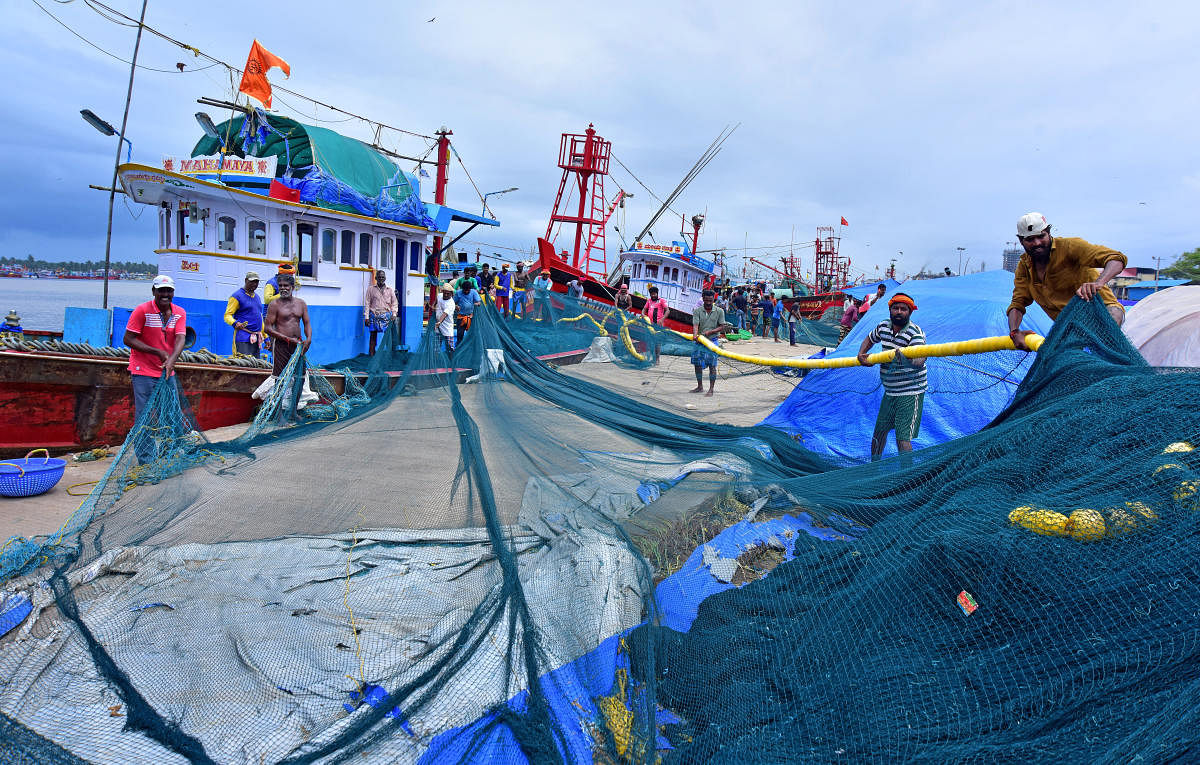 Labourers of a purse seine fishing boat make preparations to go on deep-sea fishing, at Old Port in Mangaluru on Monday. DH Photo / Govindraj Javali