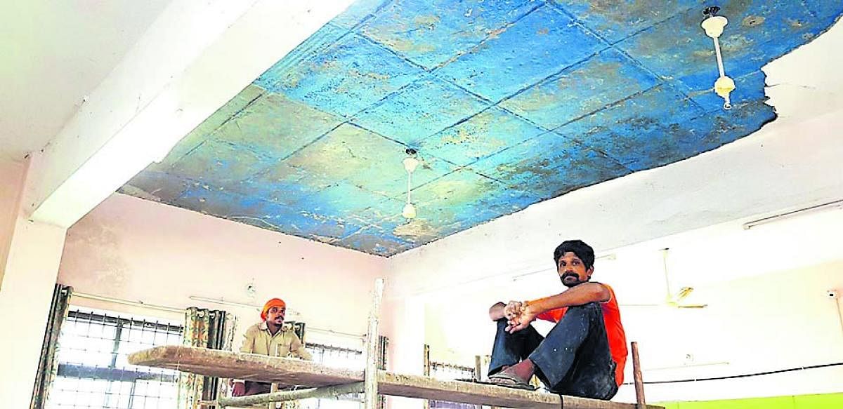 Workers repair the ceiling of the revenue office on the first floor of Mini Vidhana Soudha in Kundapur.