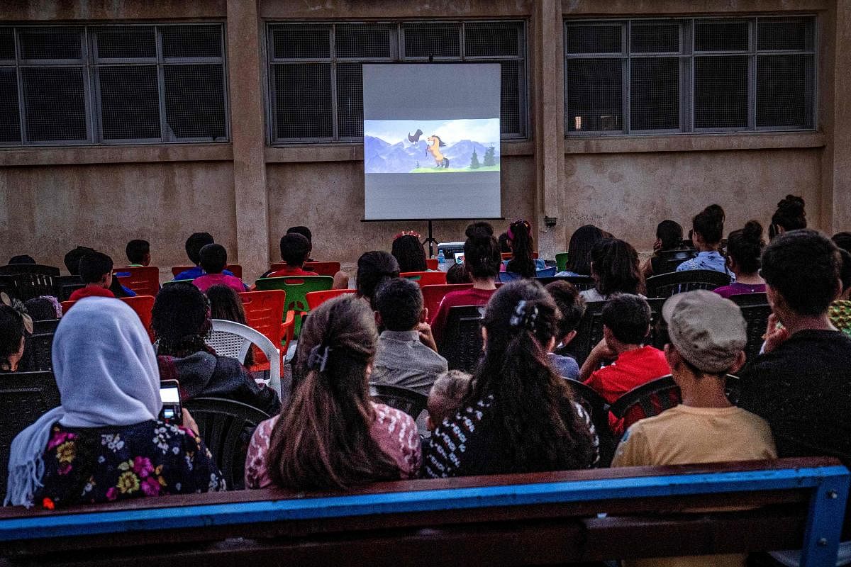 Children attend a film screening as part of the mobile cinema "Komina Film" initiative organised by Syrian-Kurdish filmmaker Shero Hinde. (AFP file photo)