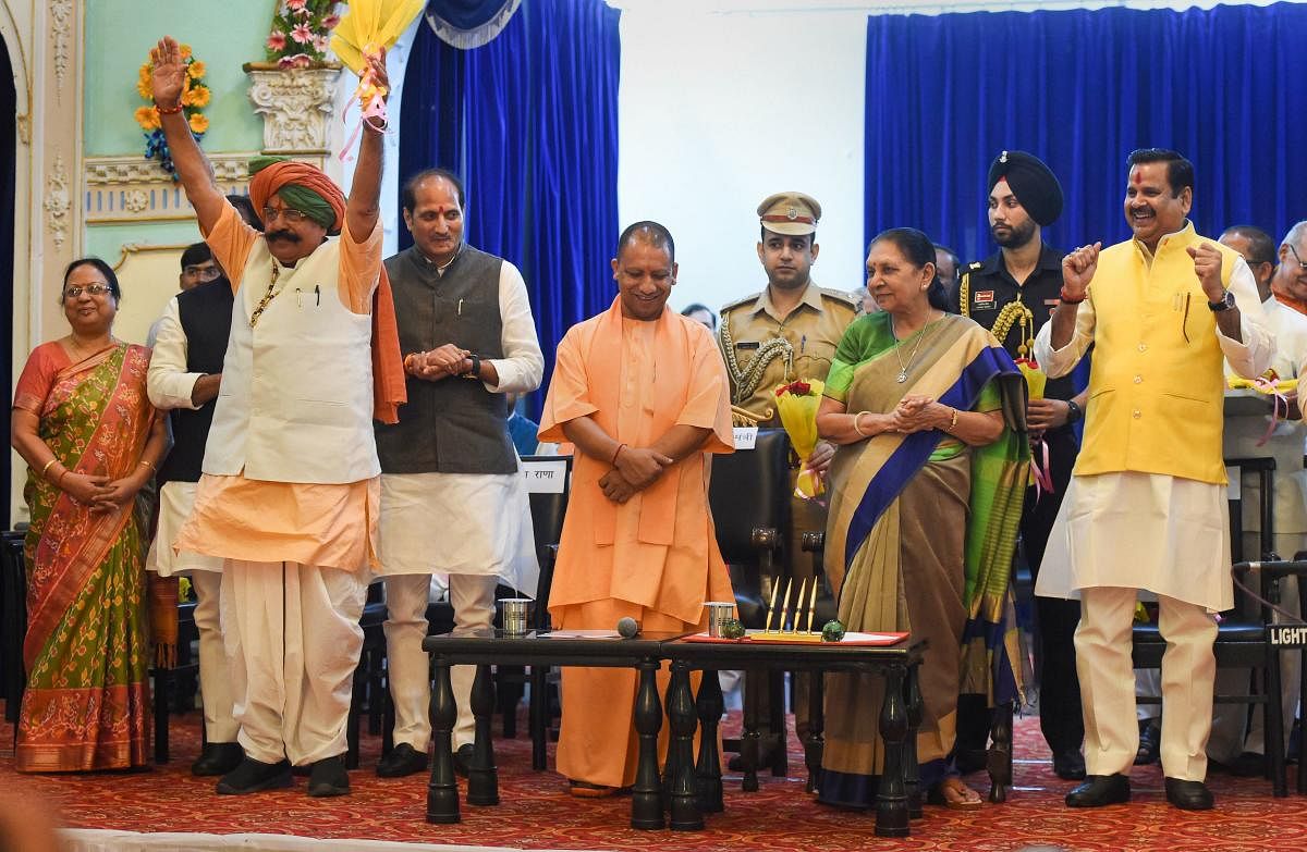 Uttar Pradesh Governor Anandiben Patel and Chief Minister Yogi Adityanath with the newly inducted ministers Uday Bhan Singh (hands raised), Suresh Rana and Mahendra Singh after their swearing-in ceremony at Raj Bhawan in Lucknow, Wednesday, Aug 21, 2019. (PTI Photo)