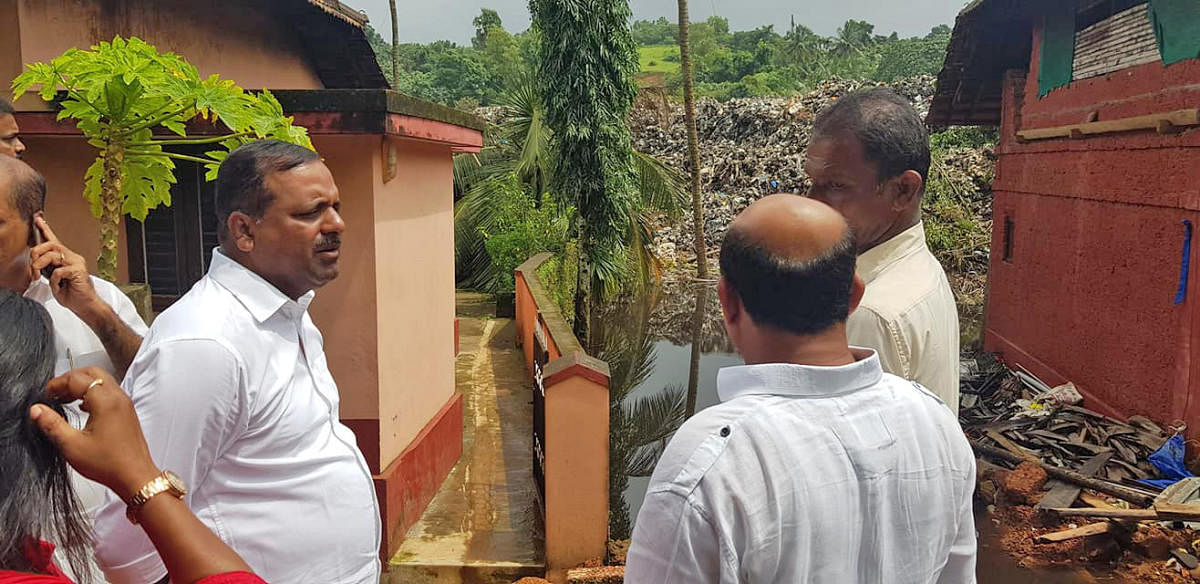 Former minister U T Khader and others visit areas at Pacchanady affected with the sliding of garbage on Wednesday.