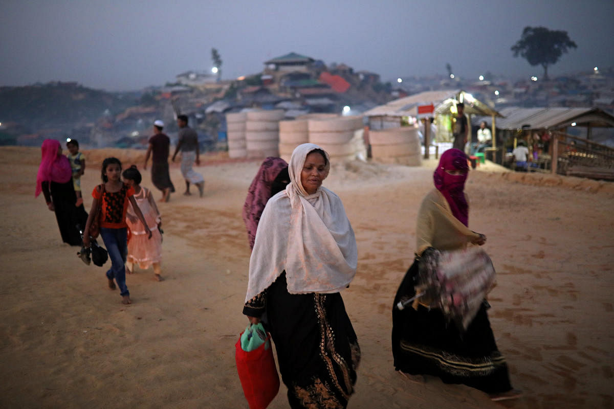 Rohingya refugees walk along the road in the evening at Balukhali camp in Cox’s Bazar, Bangladesh. Reuters File Photo