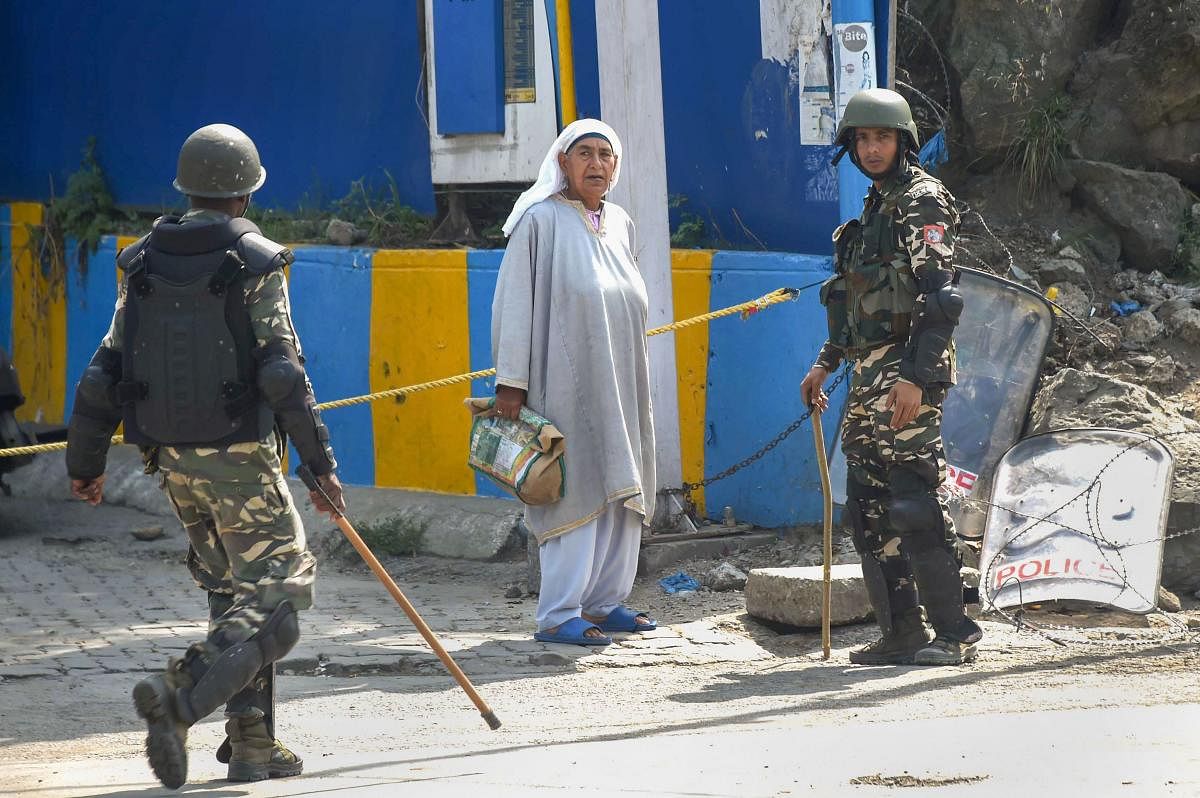 An elderly woman seeks permission from security personnel during restrictions, in Srinagar, Friday, Aug. 23, 2019. (PTI)