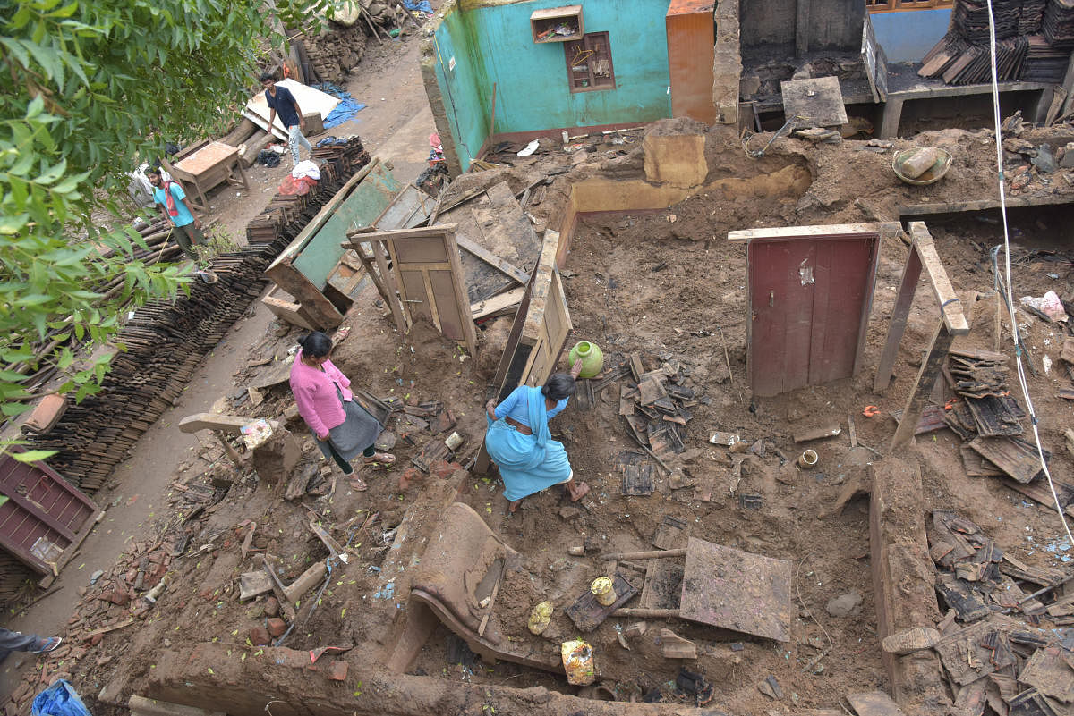 Lingamma rummages through the remains of her house for her belongings, following floods at Karadikodu Virajpete taluk in Madikeri district on Thursday. dh photo/B H Shivakumar