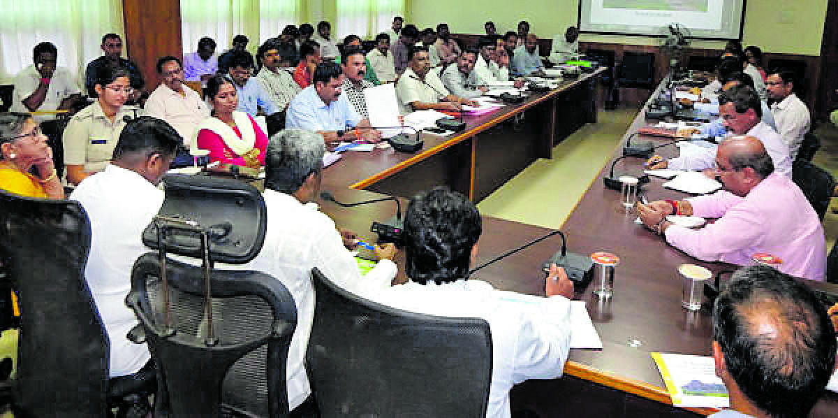 Minister Kota Srinivas Poojary attends a review meeting to take stock of flood relief work in Deputy Commissioner's office in Udupi on Thursday.