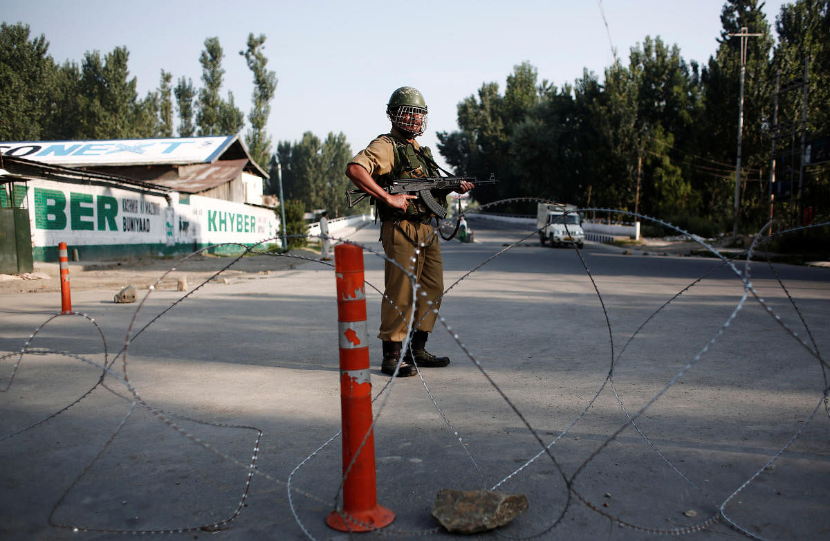 An Indian security personnel stands guard on a deserted road during restrictions after scrapping of the special constitutional status for Kashmir by the Indian government, in Srinagar. (Reuters Photo)