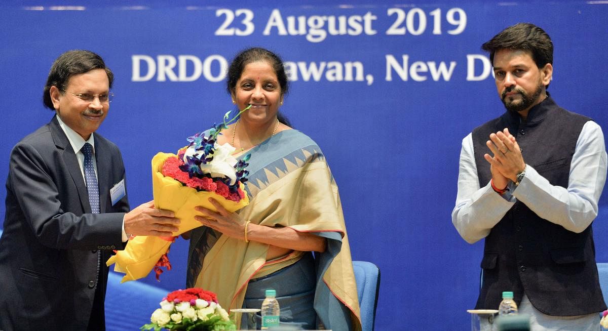 Finance Minister Nirmala Sitharaman is welcomed by Ashok Kumar Gupta, Chairperson of the Competition Commission of India (CCI) as MoS for Finance Anurag Thakur applauds during a function to celebrate 'Ten Years of Competition Law Enforcement' at DRDO Bhaw
