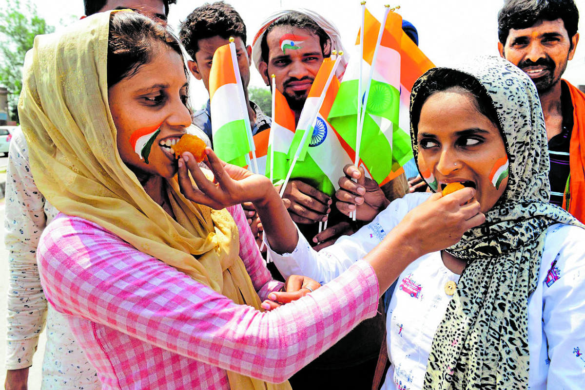Women put sweets in each others mouths during celebrations for the move to remove Article 370 for special status for Jammu and Kashmir (Photo AFP)