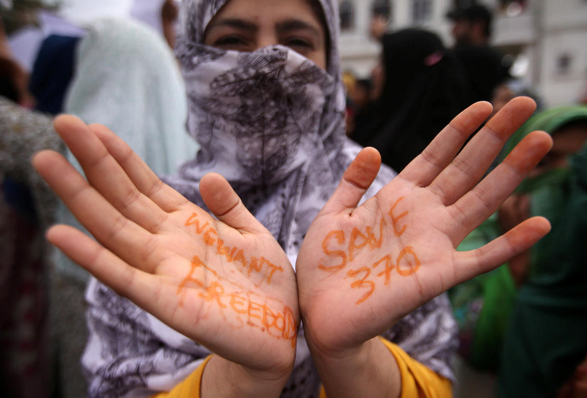 A Kashmiri woman shows her hands with messages at a protest after Friday prayers during restrictions after the Indian government scrapped the special constitutional status for Kashmir in Srinagar August 16, 2019. (REUTERS/Danish Ismail)