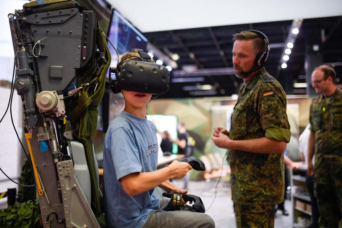 A boy visits the German Armed Forces Bundeswehr stand during the Video games trade fair Gamescom in Cologne, western Germany, on August 21, 2019. (Photo by Ina FASSBENDER / AFP)