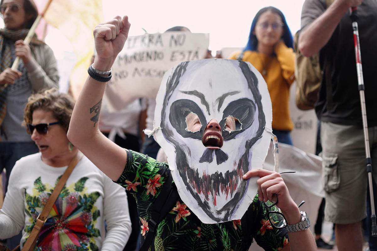 A demonstrator holds a paper mask in the shape of a skull during a protest to demand more Amazon rainforest protection at the embassy of Brazil in Quito, Ecuador August 23, 2019. REUTERS/Daniel Tapia