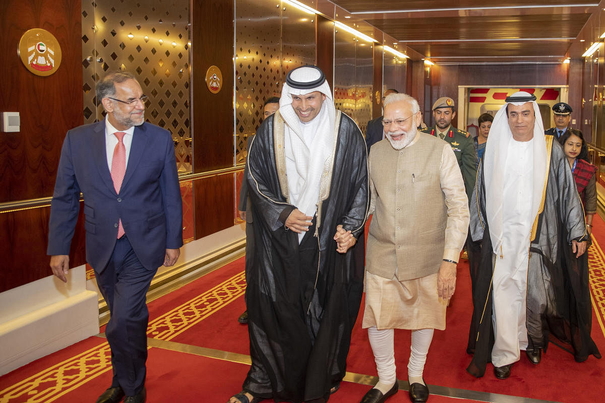 Indian Prime Minister Narendra Modi, second from right, walks with Khaldoon Khalifa al-Mubarak, second from left, chairman of the Abu Dhabi Executive Affairs Authority, after arriving in Abu Dhabi, United Arab Emirates. AP/PTI photo