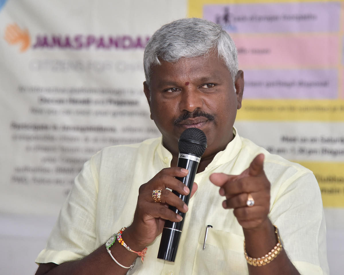 Begur corporator M Anjinappa speaks at Janaspandana, a civic grievance redress meet organised by DH and Prajavani, in Begur on Saturday. DH PHOTO/JANARDHAN B K