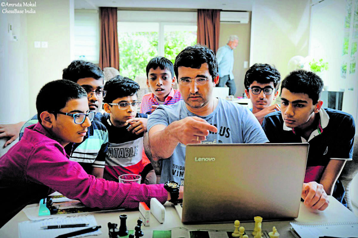 Chess legend Vladimir Kramnik (centre) explains a move to aspiring kids, part of Kramnik-Microsense programme, in Geneva.