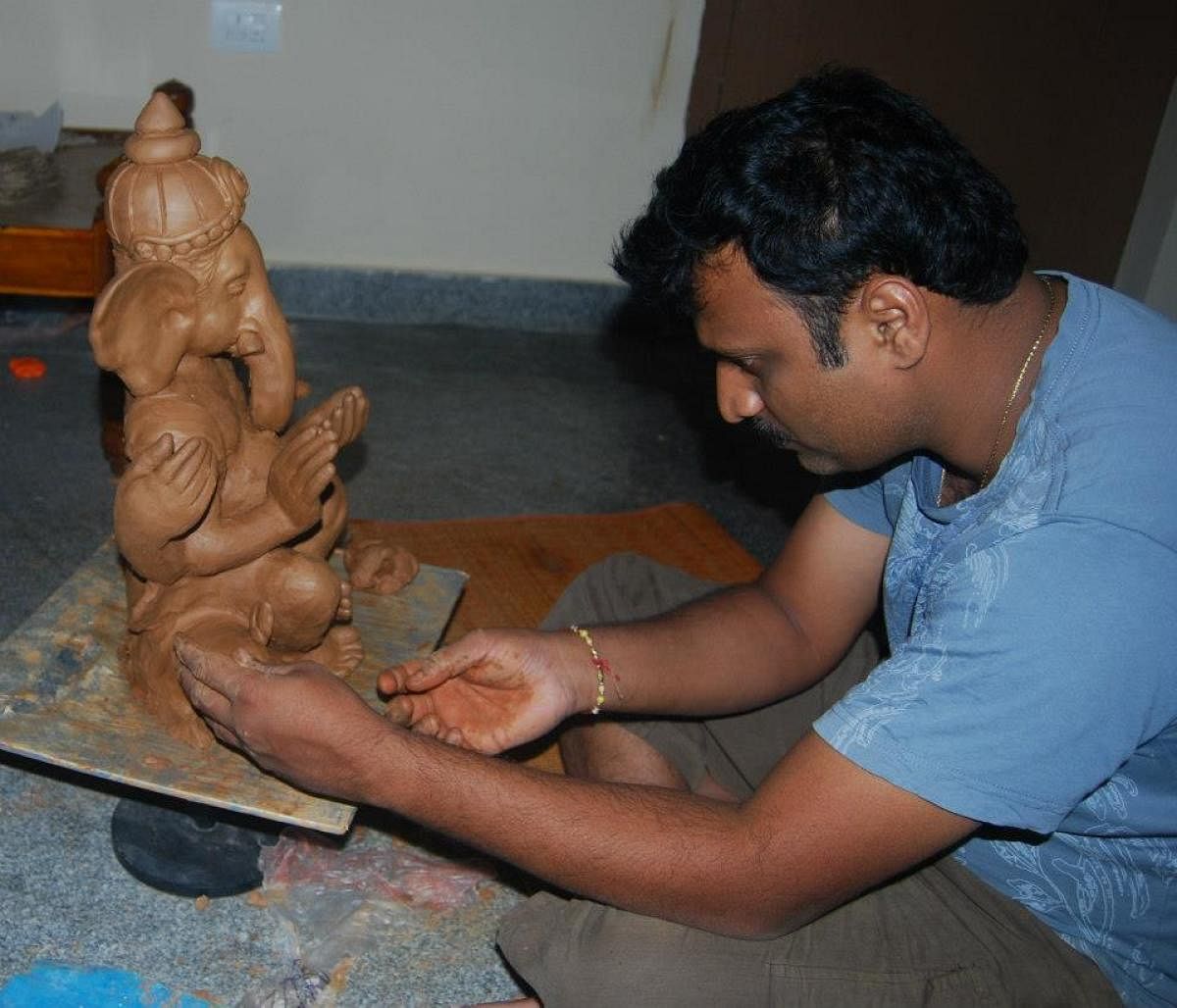 Chandrashekar G M working on a clay Ganesha sculpture.