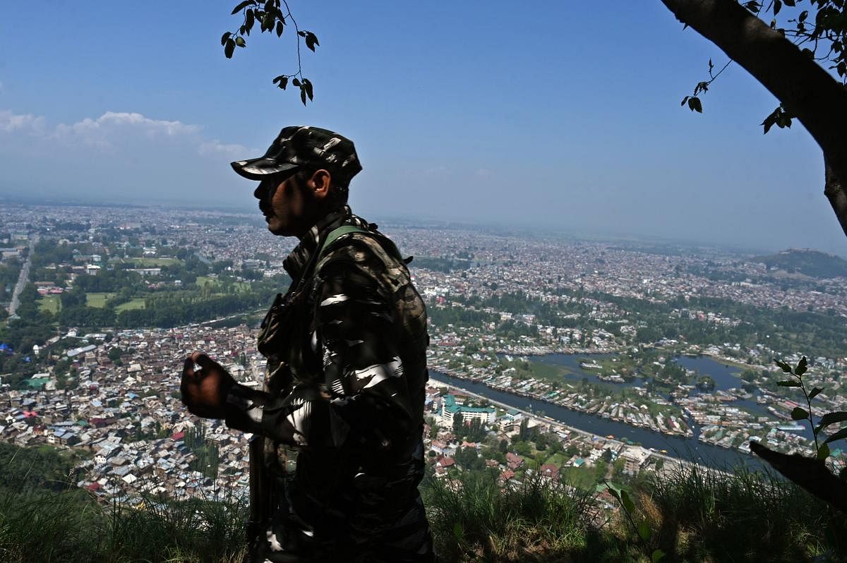 An Indian paramilitary trooper patrols at the top of a hill in Srinagar. (AFP Photo)