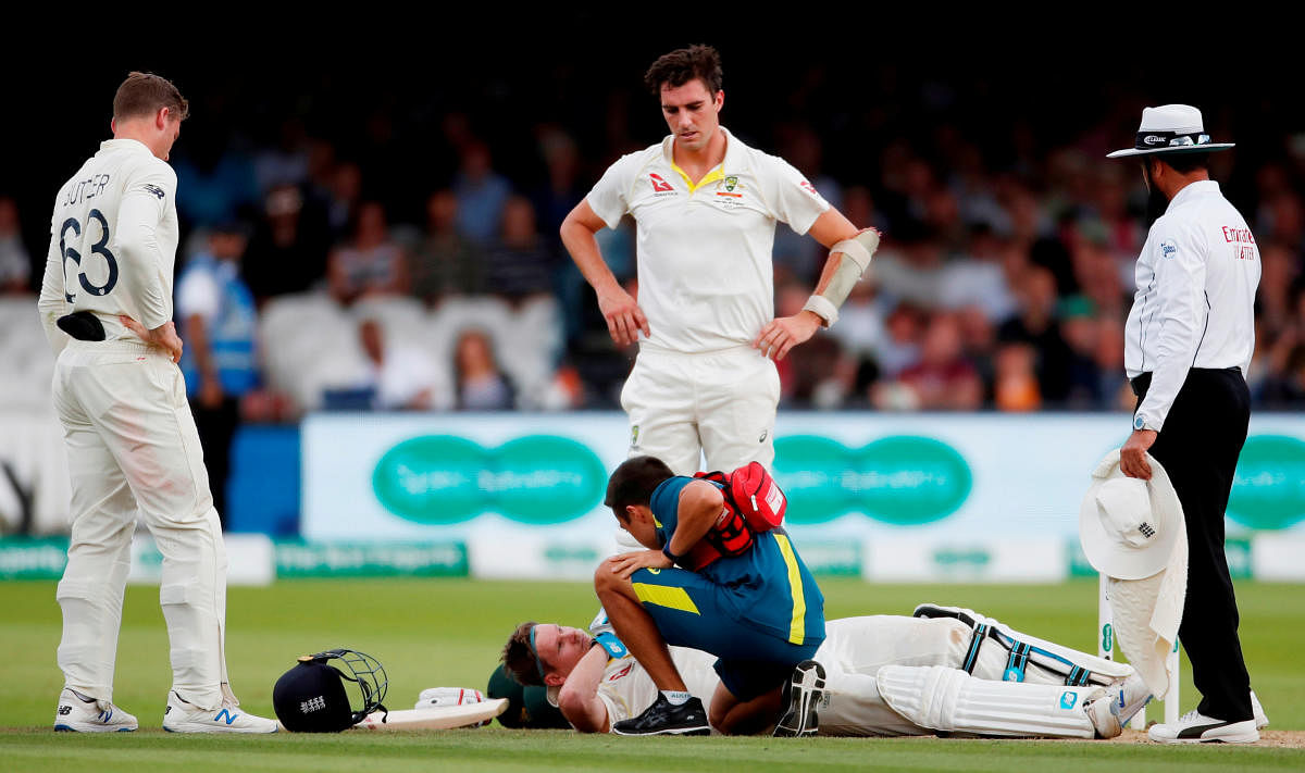 Australia's Steve Smith receives treatment as he lays on the floor after being hit by a ball from England's Jofra Archer as England's Jos Buttler and Australia's Pat Cummins. (Reuters Photo)