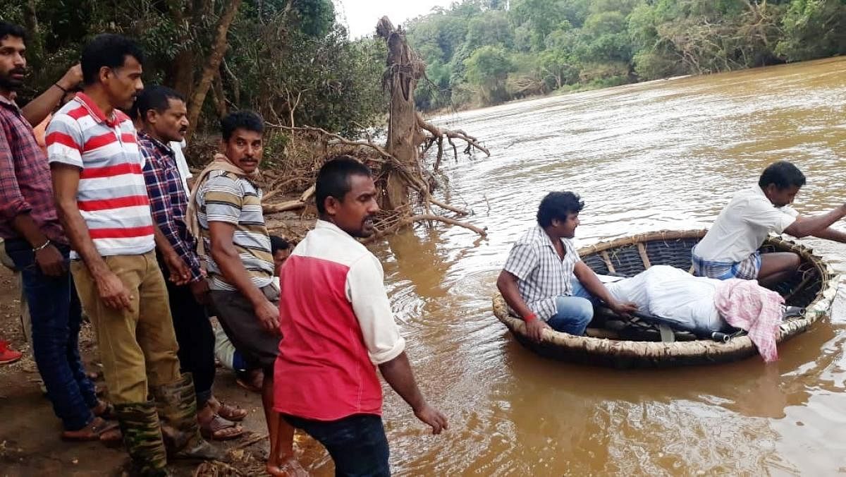 The body of Raghavendra being carried in a coracle to Holekudige village in Mudigere taluk.