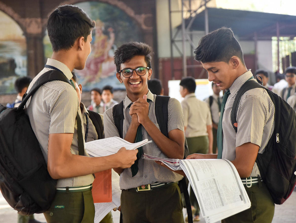 Students busy in last minute preparations for SSLC 1st day exam, before entering the exam hall, in Mysuru on Thursday. - PHOTO / SAVITHA B R