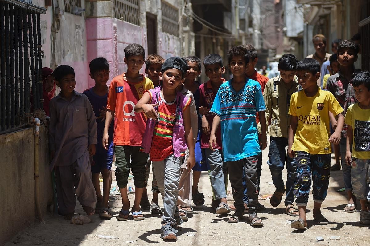 In this picture taken on May 19, 2019, eight-year-old rapper Waqas Baloch (C) performs in Lyari, one of Pakistan’s most dangerous neighbourhoods, in Karachi. (Photo by RIZWAN TABASSUM / AFP)