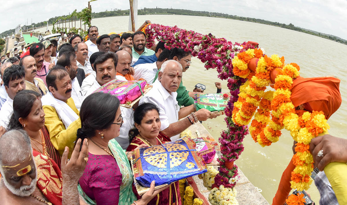 Chief Minister B S Yediyurappa offers bagina to River Cauvery at KRS dam in Mandya district on Thursday. MP A Sumalatha, Mysuru Mayor Pushpalatha Jagannath, ex-MLA Narayan Gowda, MLA Ravindra Srikantaiah and Revenue Minister R Ashoka are seen.