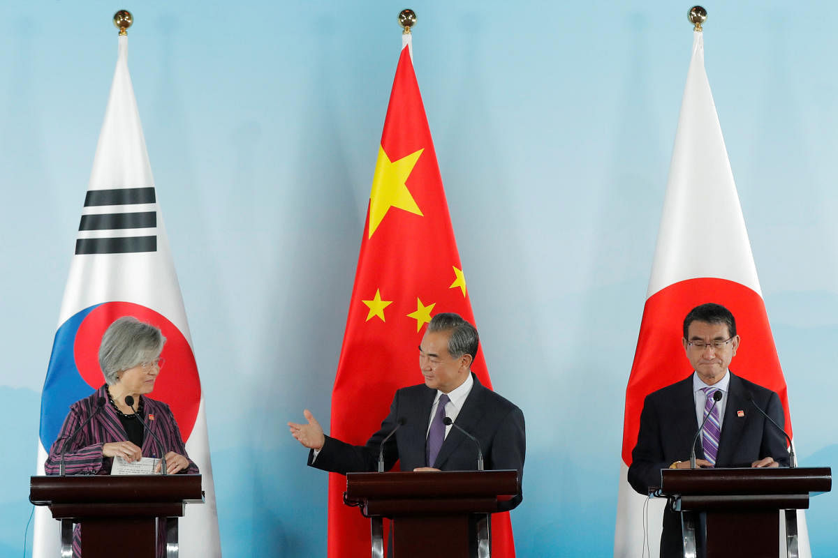 Chinese Foreign Minister Wang Yi (C) gestures to South Korean Foreign Minister Kang Kyung-wha (L) beside Japanese Foreign Minister Taro Kono (R) during a press conference after the ninth trilateral foreign ministers’ meeting among China, South Korea and Japan at Gubei Town in Beijing, China, 21 August 2019. REUTERS