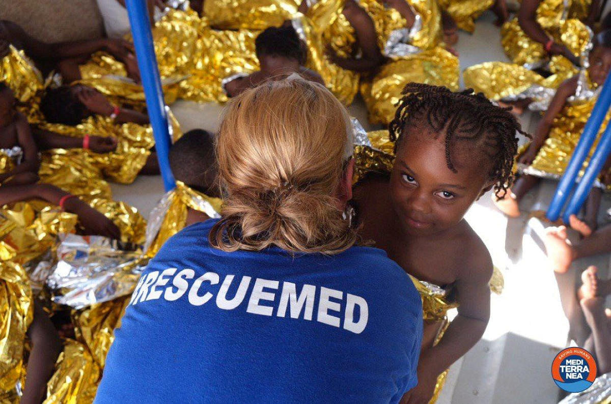 A member of the Italian charity Mediterranea Saving Humans is seen with migrants rescued off the Libyan coast onboard rescue ship the Mare Jonio. Reuters photo