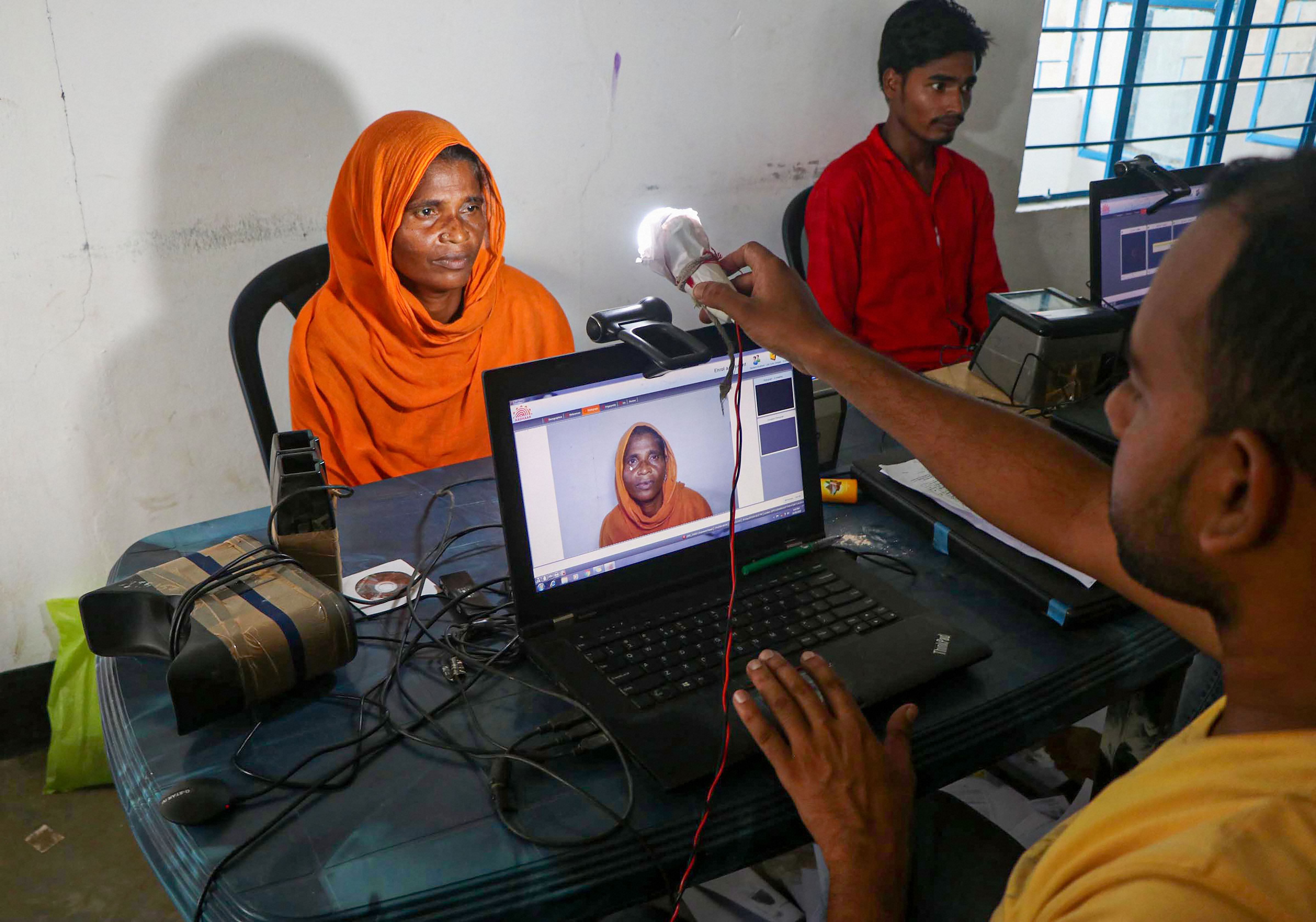 Kamrup: An official takes photo of an applicant to submit her bio-metrics data ahead of NRC final draft publication at Hatipara village in Kamrup. (PTI Photo)