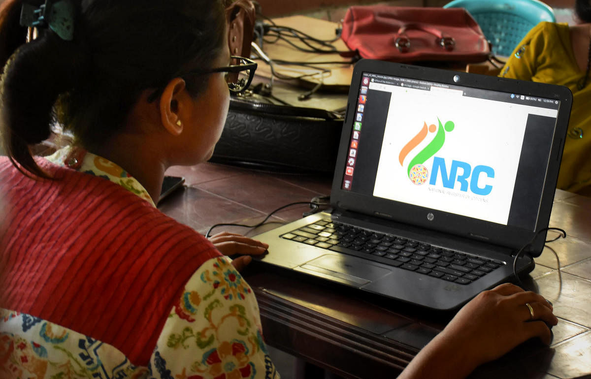 An official checks the documents submitted by people at a National Register of Citizens (NRC) Seva Kendra in Guwahati. PTI file photo