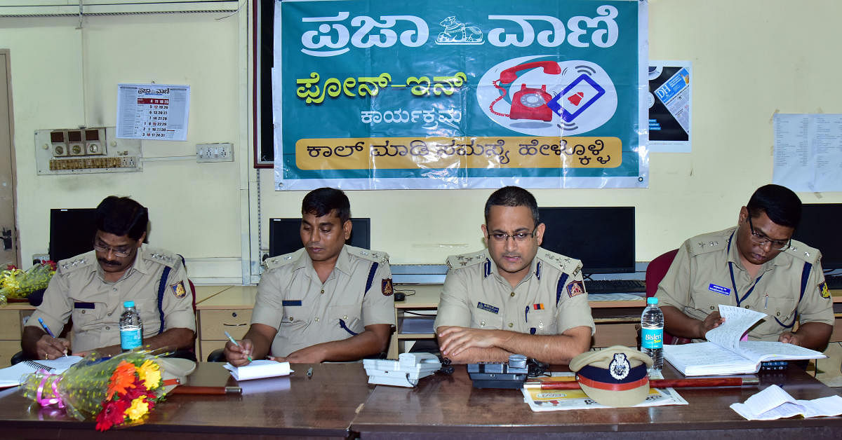 Commissioner of Police Dr P S Harsha receives a call during the phone-in programme organised by Prajavani at DH-PV editorial office in Balmatta on Friday. DH PHOTO