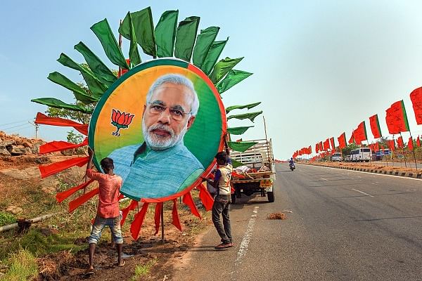 Workers place a huge portrait of Prime Minister Narendra Modi along a road ahead of his rally, in Kanyakumari, Thursday, Feb. 28, 2019. PTI Photo