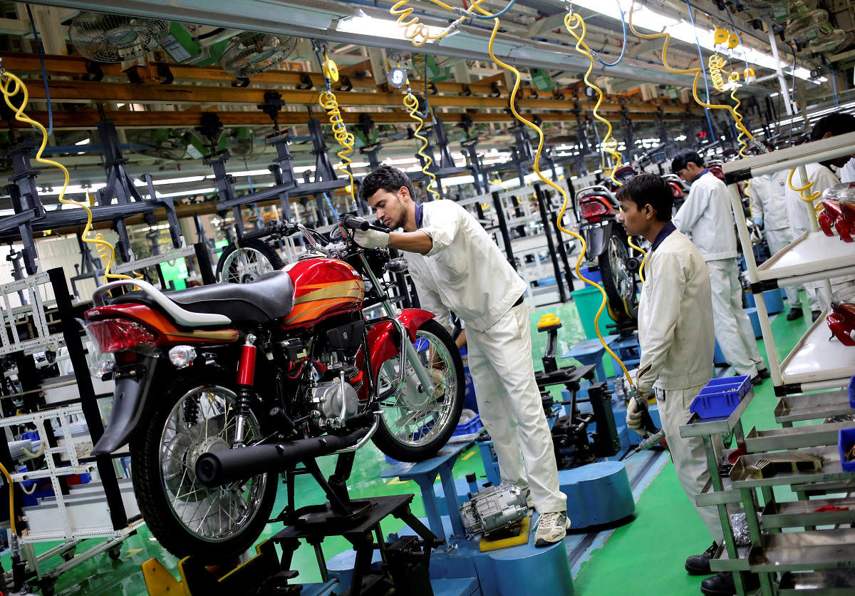 FILE PHOTO: Employees work on an assembly line of Hero MotoCorp during a media tour to the newly opened plant in Neemrana, Rajasthan. Reuters