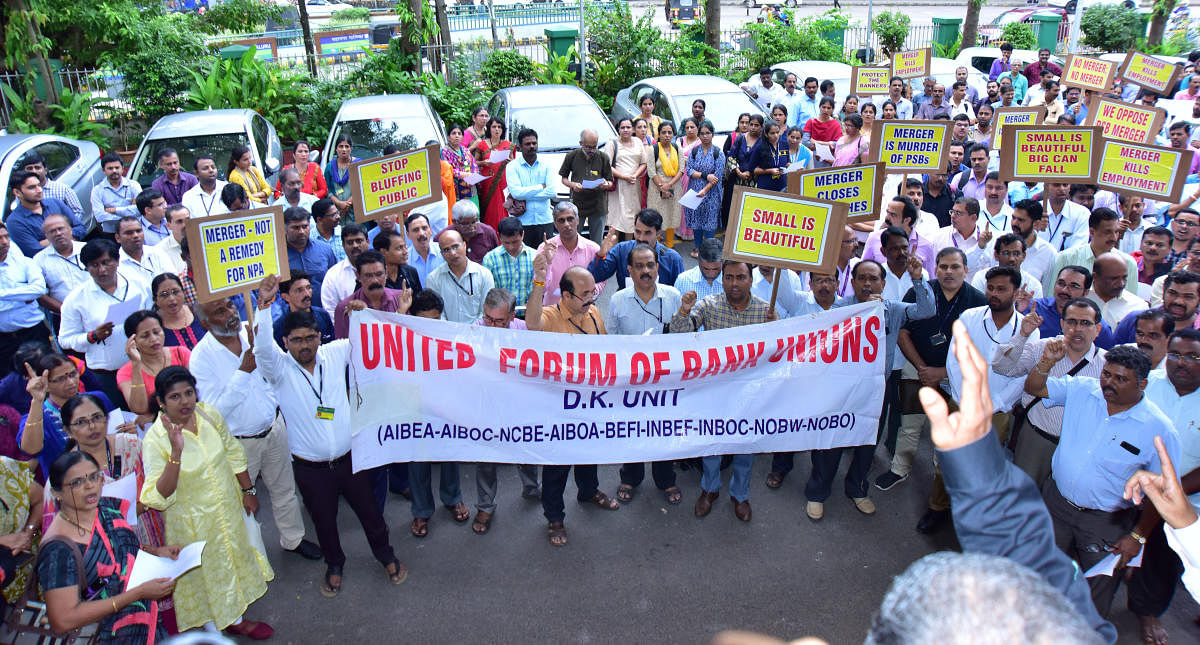 Bank staff stage a protest in front of Corporation Bank head office in Mangaluru on Saturday against the Central government decision to merge banks.
