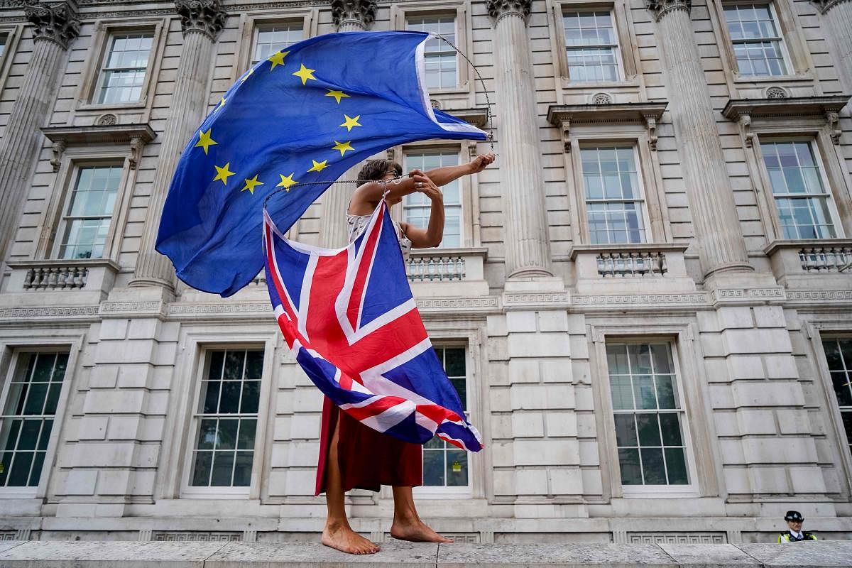 An anti-Brexit demonstrator whirls an EU and Union Flag during a demonstration against the British government's move to suspend parliament in the final weeks before Brexit outside Downing Street in London on August 31, 2019. (Photo by AFP)
