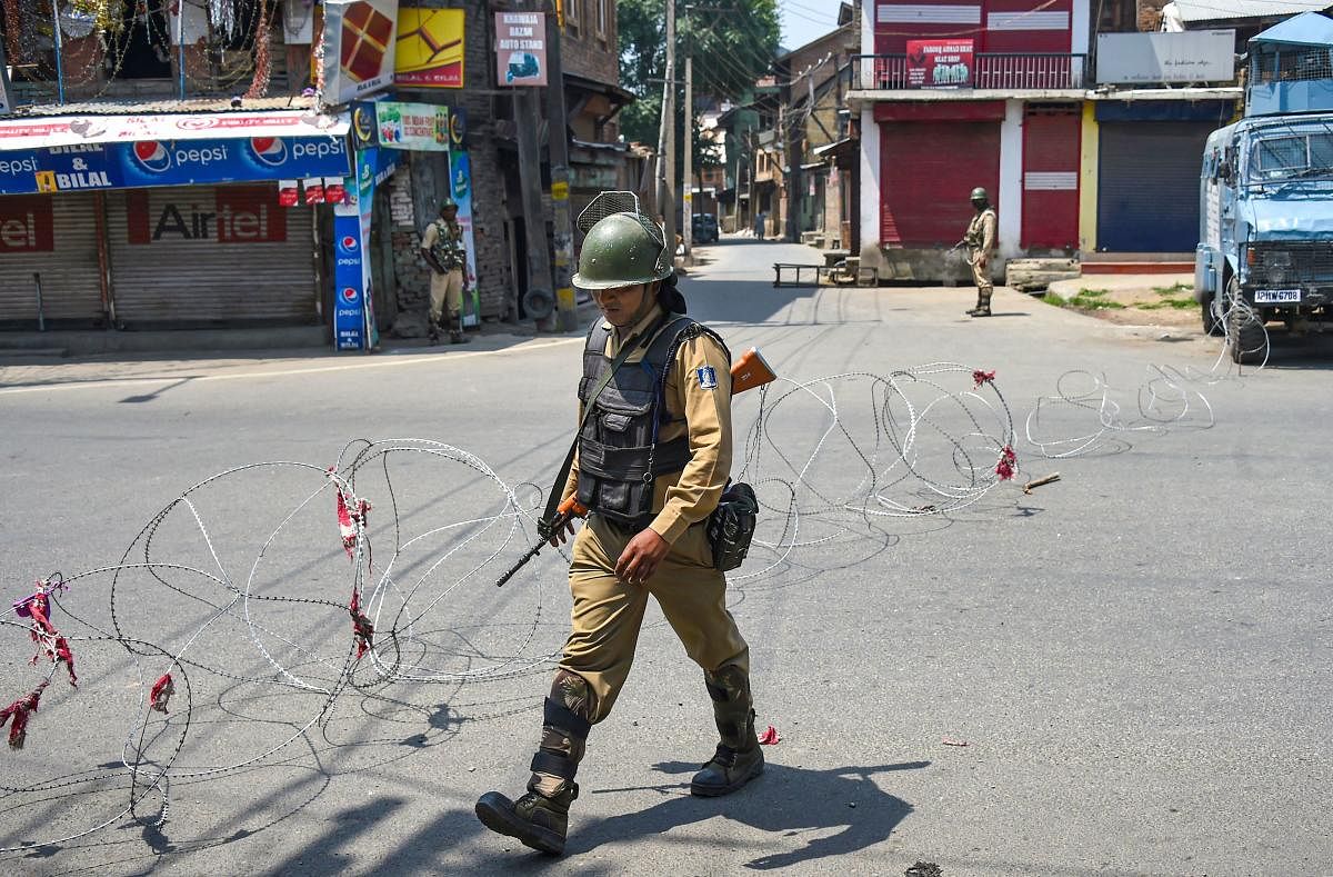 CRPF personnel stand guard during a strike called by separatist leaders on the third death anniversary of Hizbul Mujahideen militant commander Burhan Wani, in Srinagar, Monday, July 8, 2019. (PTI Photo/S. Irfan)