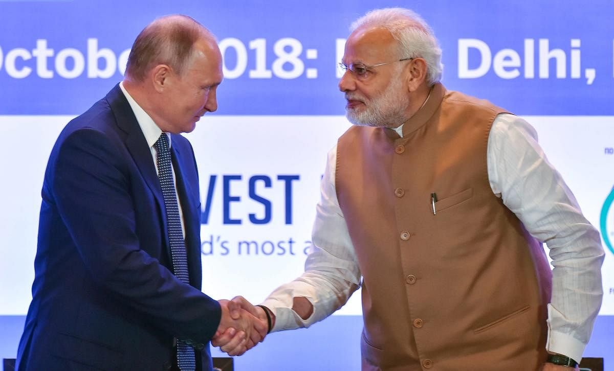 Prime Minister Narendra Modi shakes hands with Russian President Vladimir Putin during India-Russia Business Summit, in New Delhi, on Friday. PTI