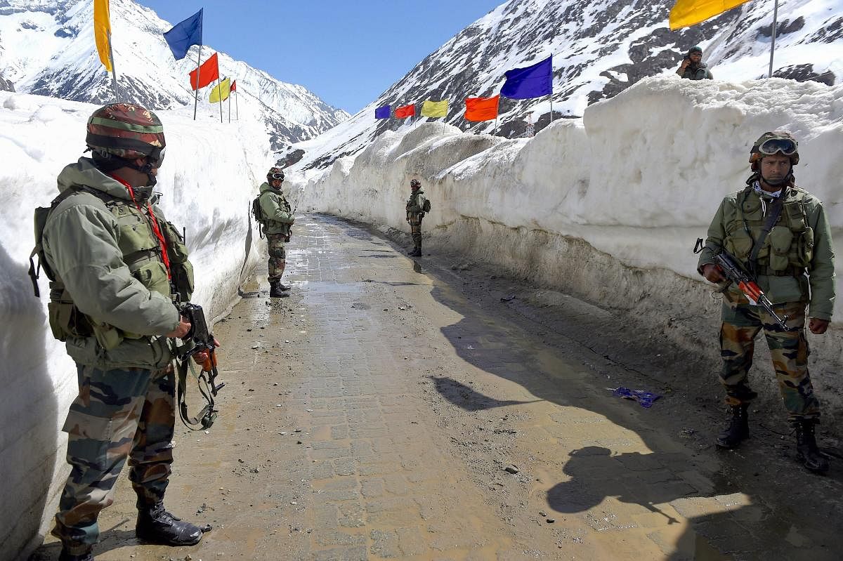 Army soldiers stand guard at snow-bound Zojila Pass, situated at a height of 11,516 feet, on its way to frontier region of Ladakh. (PTI Photo)