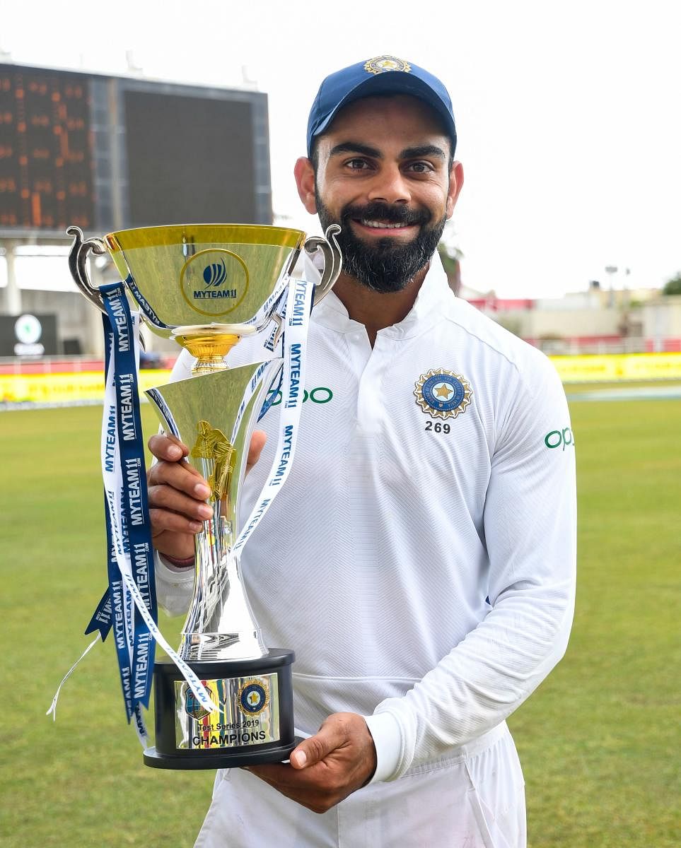 Virat Kohli poses with the trophy after winning on day 4 of the 2nd and final Test between West Indies and India at Sabina Park, Kingston, Jamaica, on September 2, 2019. (Photo by Randy Brooks / AFP)