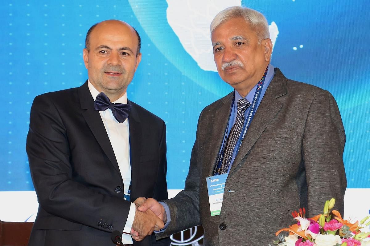Outgoing chairperson from Romania of Association of World Election Board (A-WEB), Ion Mincu Radulescu (L) shakes hands with the newly elected chairperson, Sunil Arora of India during the 4th General Assembly of A-WEB in Bangalore. (AFP photo)