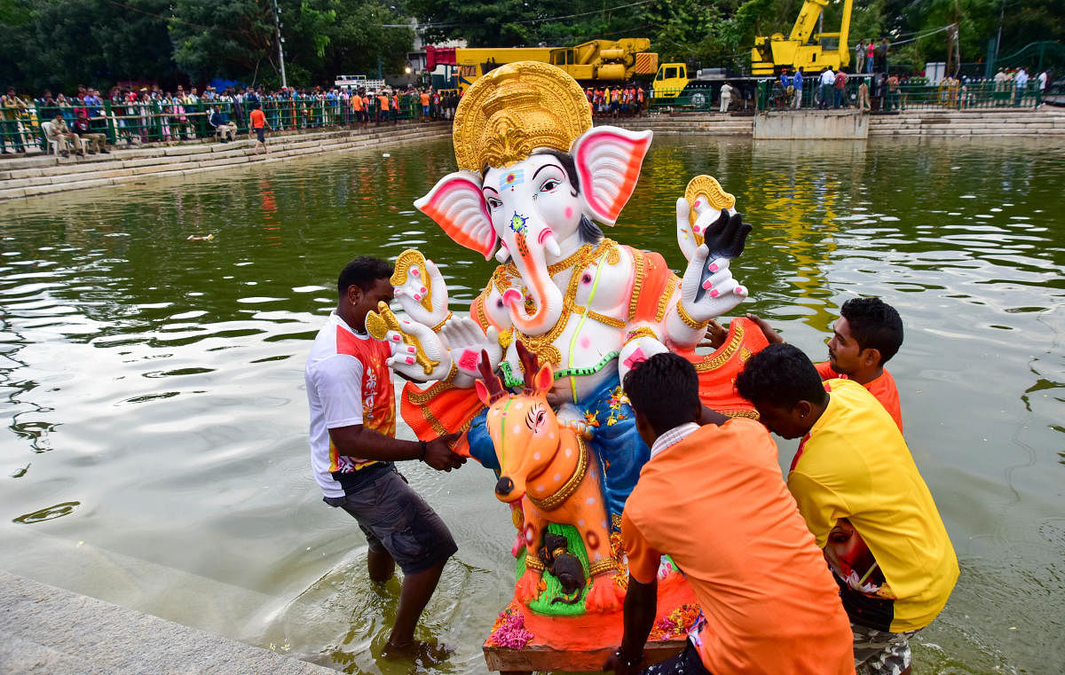 Volunteers immerse a PoP Ganesha idol in Halasuru Lake on Monday evening. DH PHOTO/IRSHAD MAHAMMAD