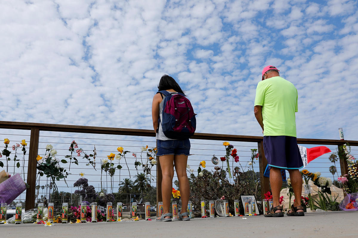People stop to pause over a makeshift memorial near Truth Aquatics as the search continues for those missing in a pre-dawn fire that sank a commercial diving boat off a Southern California island near Santa Barbara, California. (Reuters Photo)